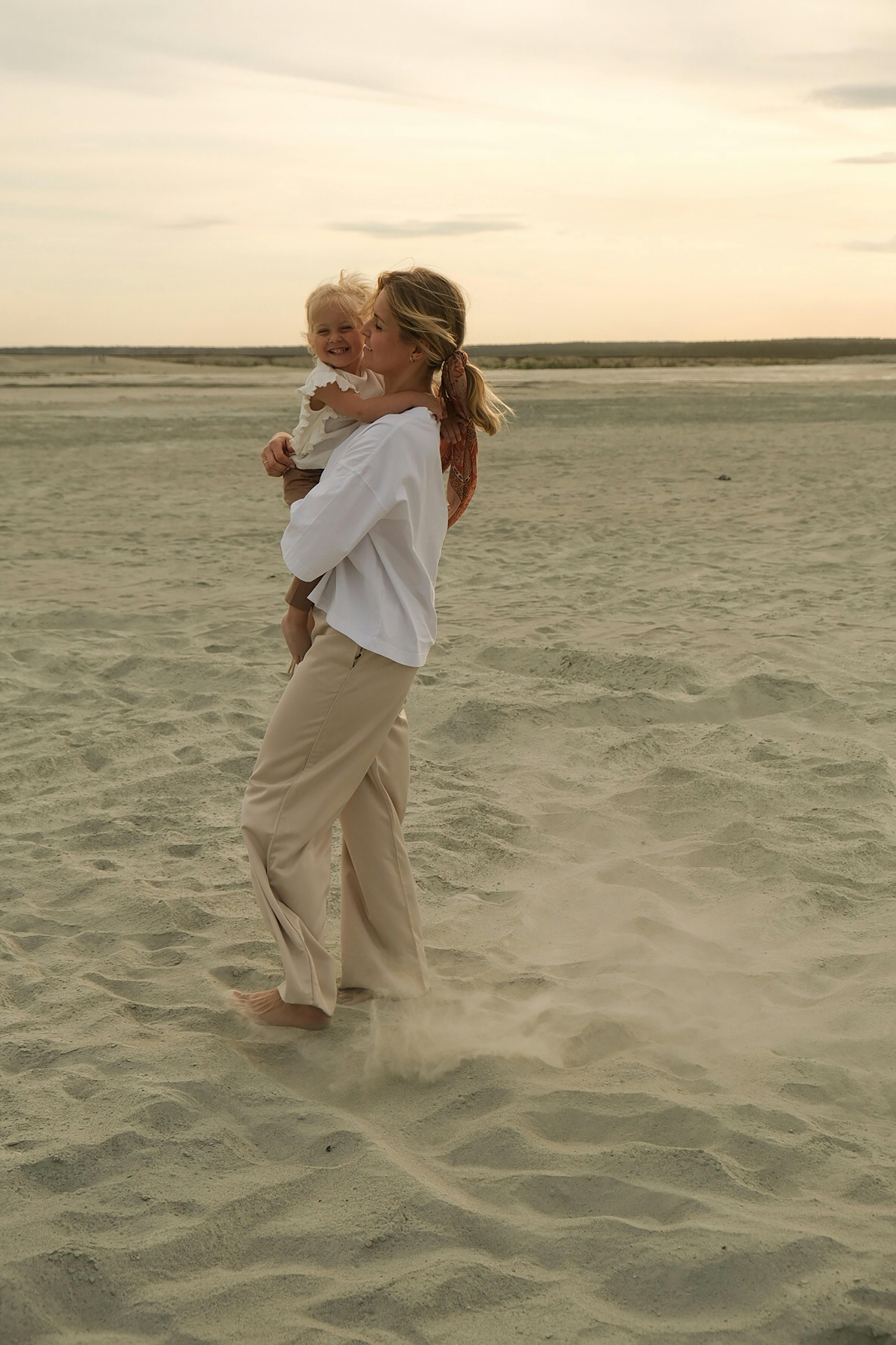 mother holding her little baby on the beach