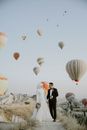 Woman in Black Jacket Standing Near Hot Air Balloons