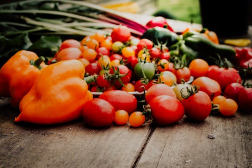 Close-Up Shot of Peppers and Tomatoes on a Wooden Surface