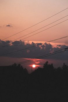 Stunning silhouette of trees and power lines at sunset in Smooth Rock Falls, Canada.