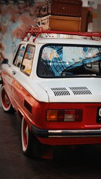 A classic vintage car with retro suitcases parked indoors in Saint Petersburg, Russia, highlighting nostalgia and travel.