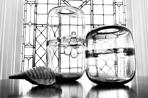 Grayscale Photo of Clear Glass Jars