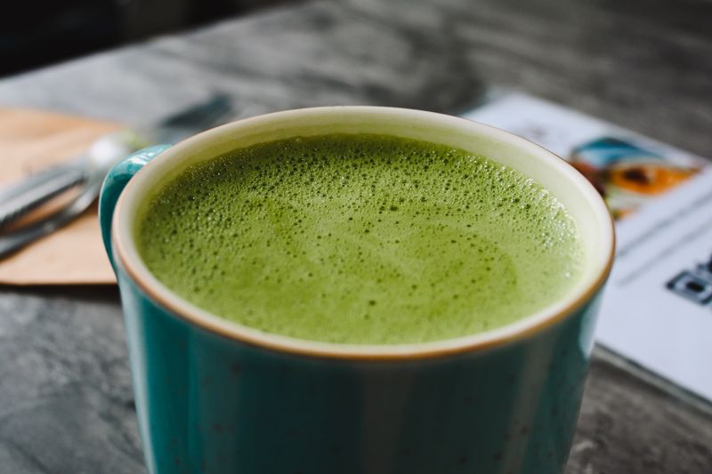 A matcha latte in a green ceramic cup