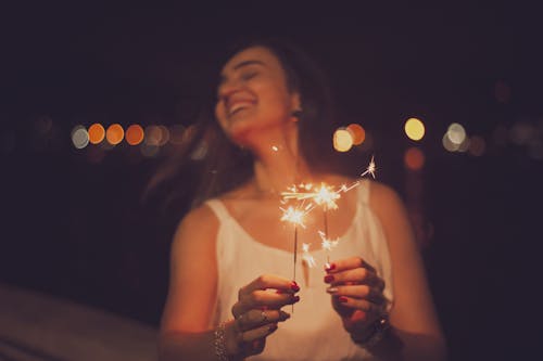 Woman in White Tank Top Holding Sparkler