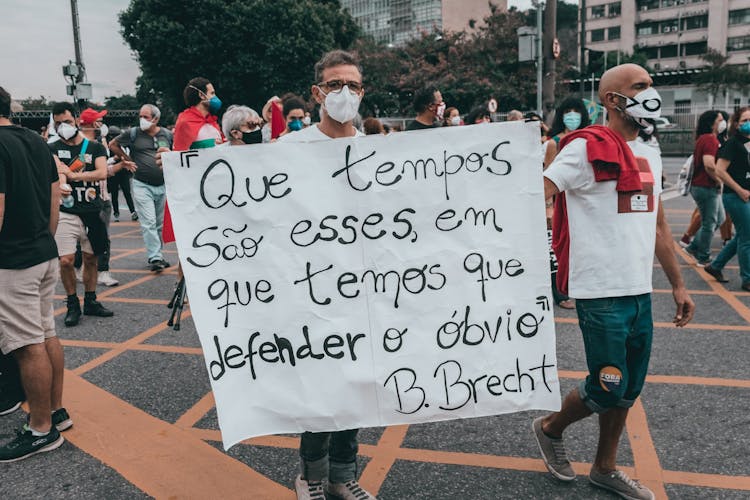 People Holding A Banner