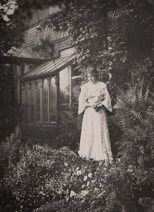 Woman in White Dress Standing on Flower Garden