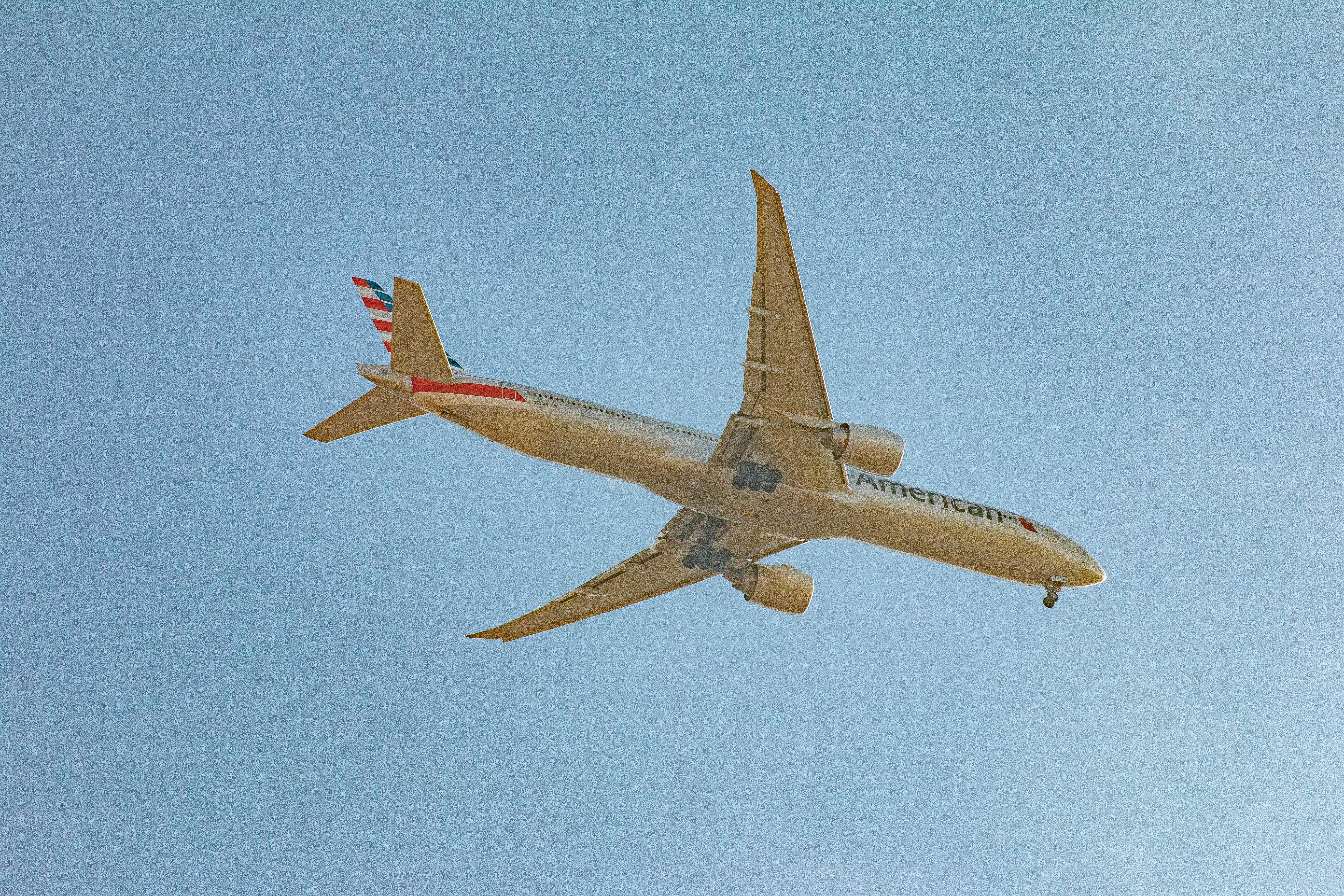 Free A commercial airplane flying high in the clear blue sky, showcasing modern air travel. Stock Photo