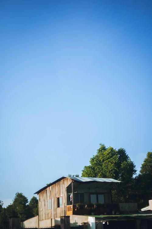 Free A rustic wooden house in rural Buon Ma Thuot, Vietnam, with a clear blue sky. Stock Photo