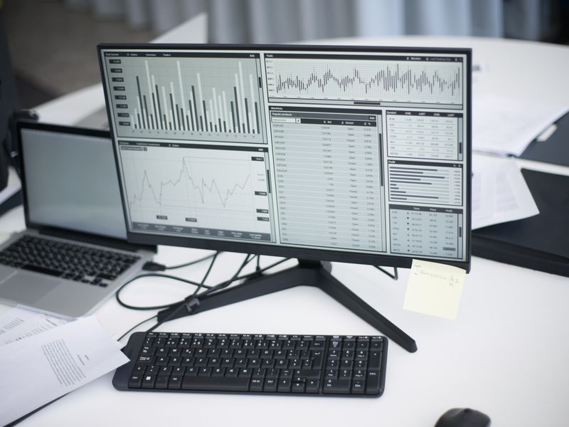 Clean desk setup with a monitor showing website and analytics graphs