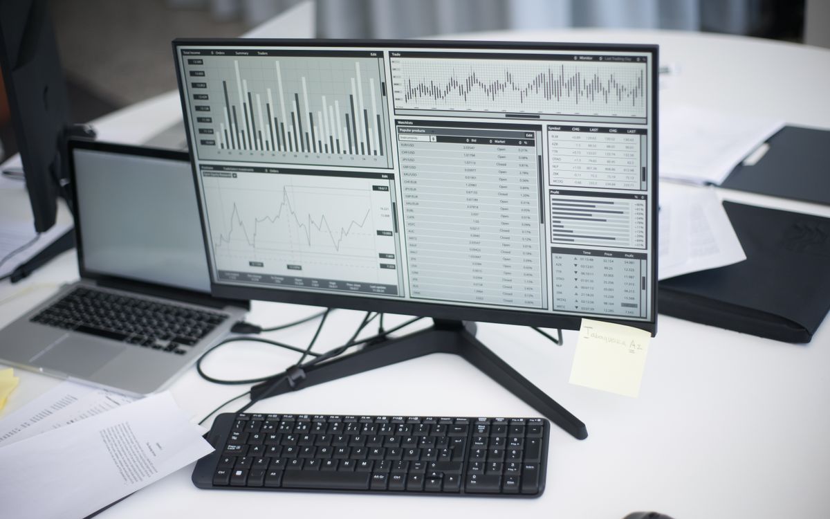 Multi-monitor analytics dashboard on an office desk