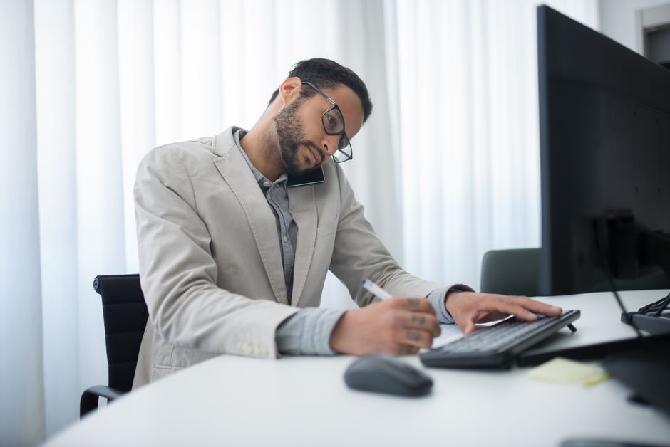 Person working on a laptop with a notebook and coffee on a desk, representing AI-assisted productivity work.