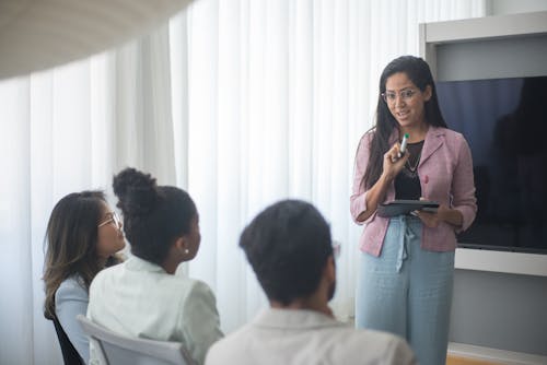 Free A Woman Giving Presentation to Colleagues Stock Photo