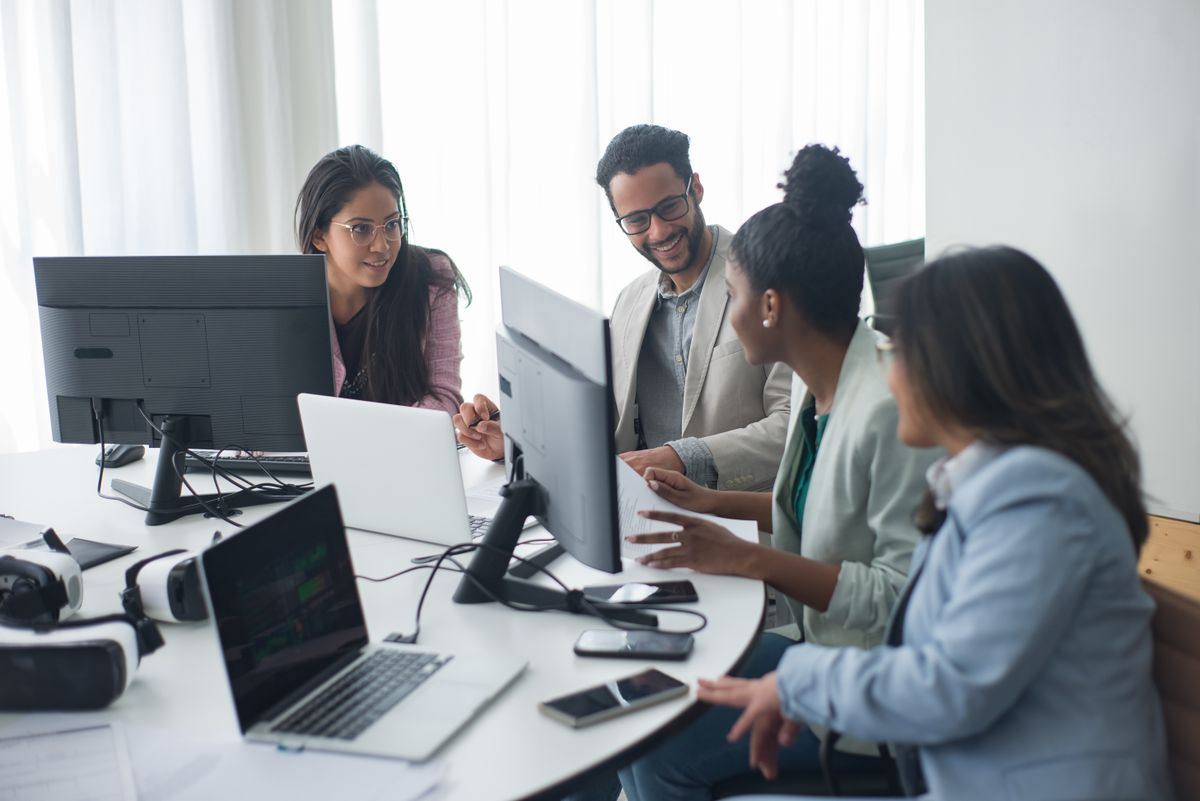 Équipe technique pluridisciplinaire collaborant autour de plusieurs écrans