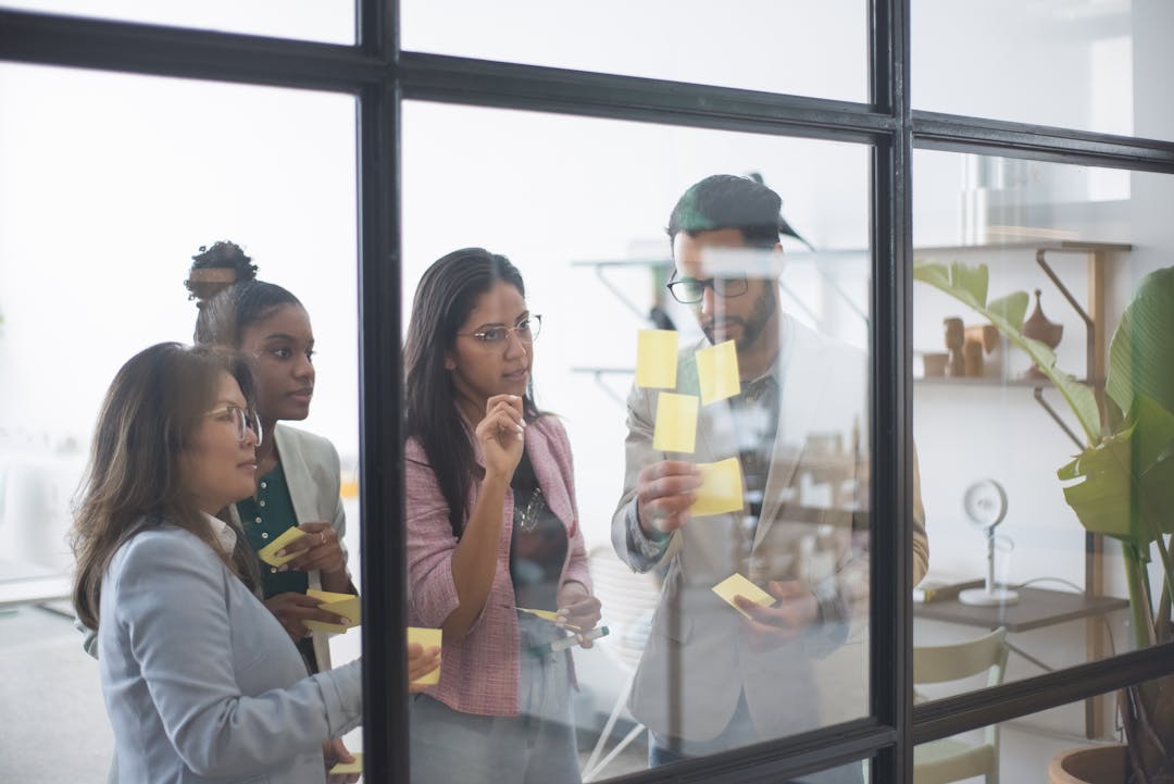 A diverse team engaged in a collaborative planning session with sticky notes in a modern office setting.