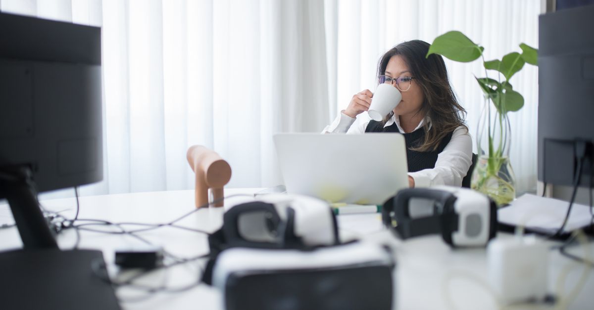person wearing VR headset working at desk with virtual screens