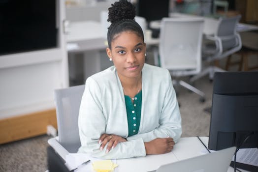 Confident young woman working at her desk in a bright modern office environment.