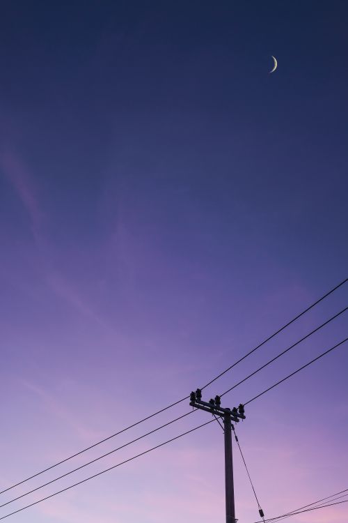 Free Silhouette of power lines under a crescent moon at dusk in Indonesia's serene landscape. Stock Photo