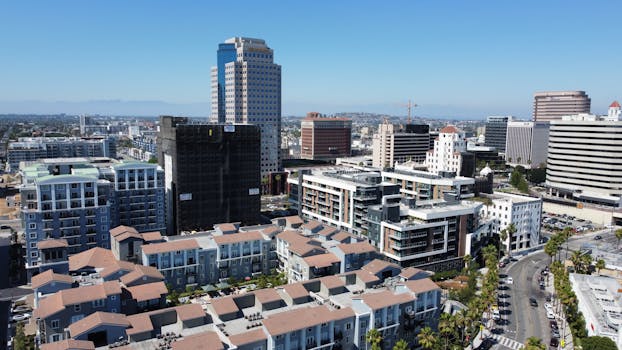 Aerial cityscape showcasing modern high-rise buildings under a clear blue sky.