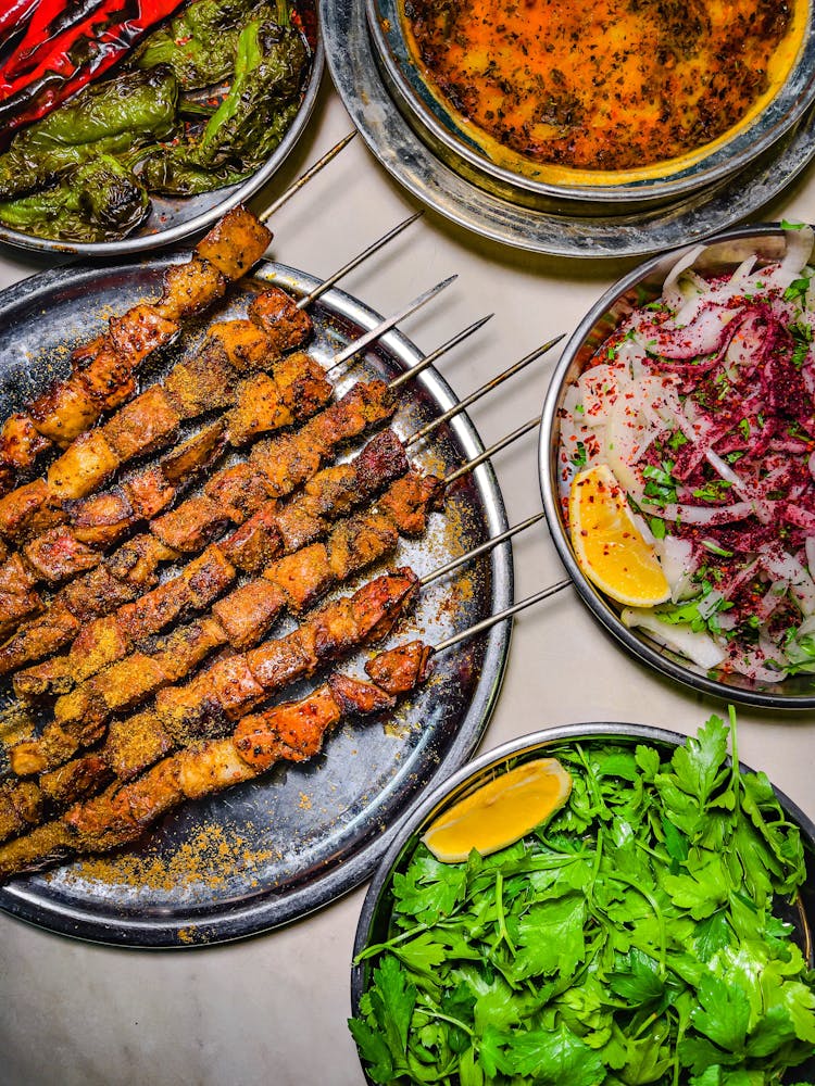 Grilled Meat On Plate With Salads In Bowls