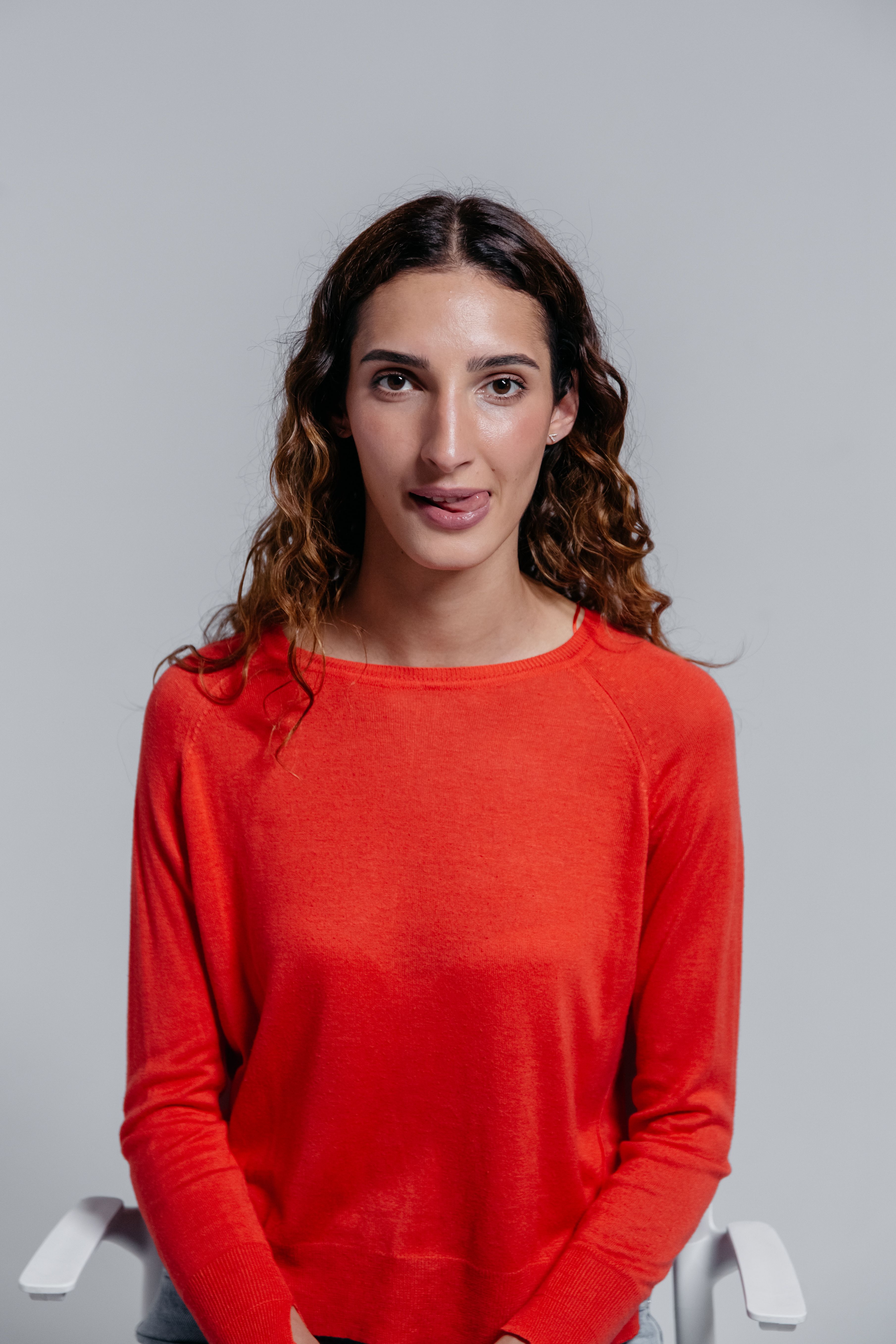 A Woman in Red Long Sleeves Sitting on a Chair · Free Stock Photo