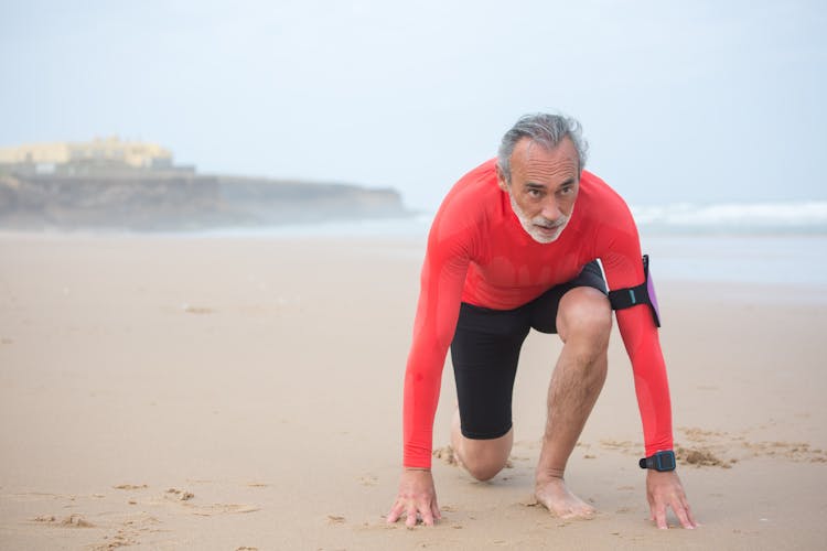 An Elderly Man Jogging On The Beach