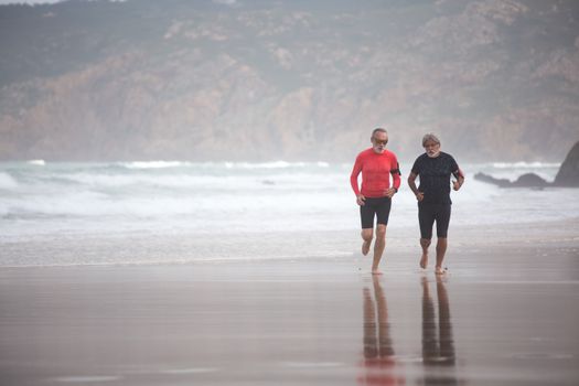 Elderly men jogging on a scenic beach in Portugal, embodying fitness and healthy living.