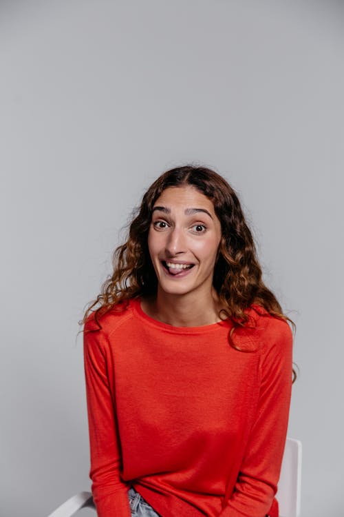 Woman in Red Crew Neck Long Sleeve Shirt Sticking Out Her Tongue 