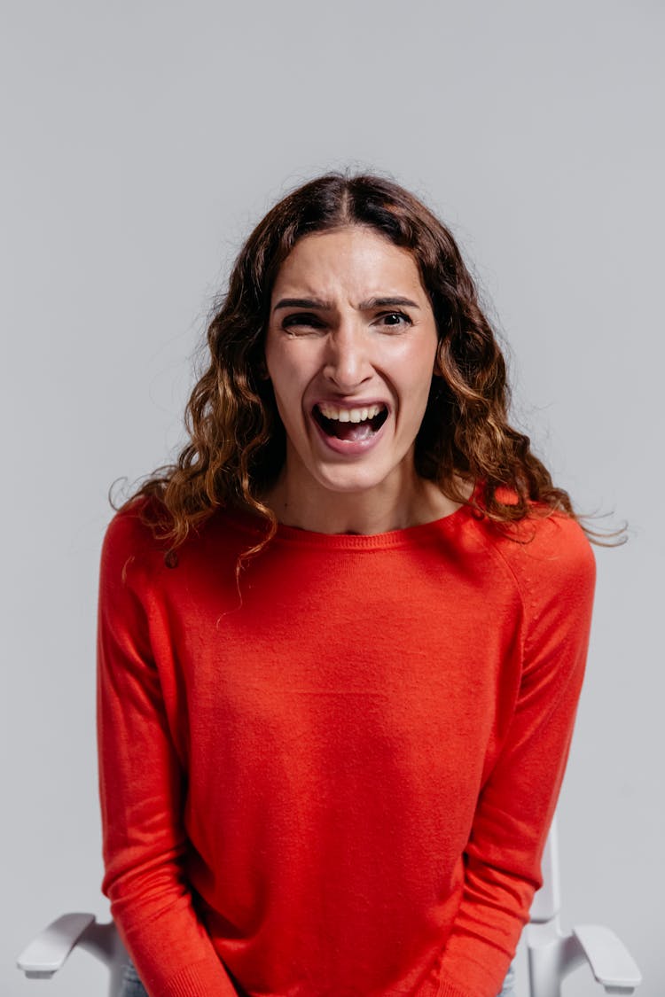 Woman In Orange Long Sleeve Shirt Feeling Irritated