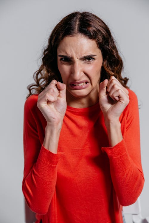 Woman in Red Long Sleeve Shirt Feeling Irritated