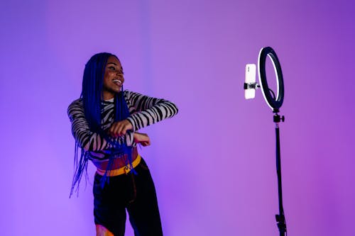 A Woman in Animal Print Long Sleeves Dancing in Front of Ring Light with Cellphone
