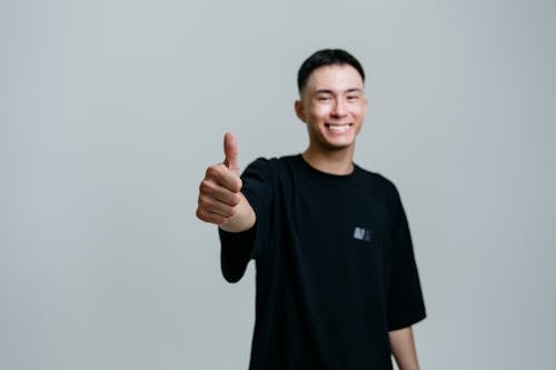 Selective Focus Photo of a Man in a Black Shirt Doing the Thumbs Up