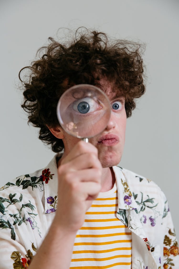 A Man Holding A Magnifying Glass