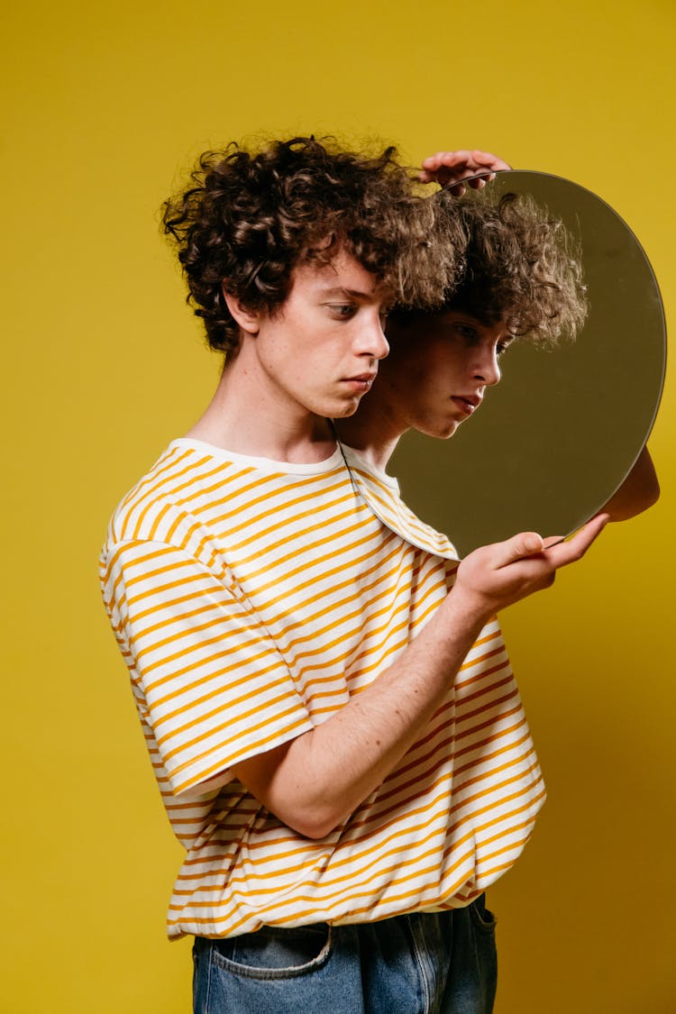 A Man Holding A Mirror