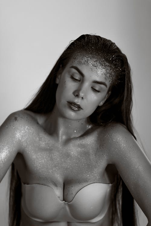 Grayscale Photo of Woman Wearing Strapless Brassiere With Glitters on Body