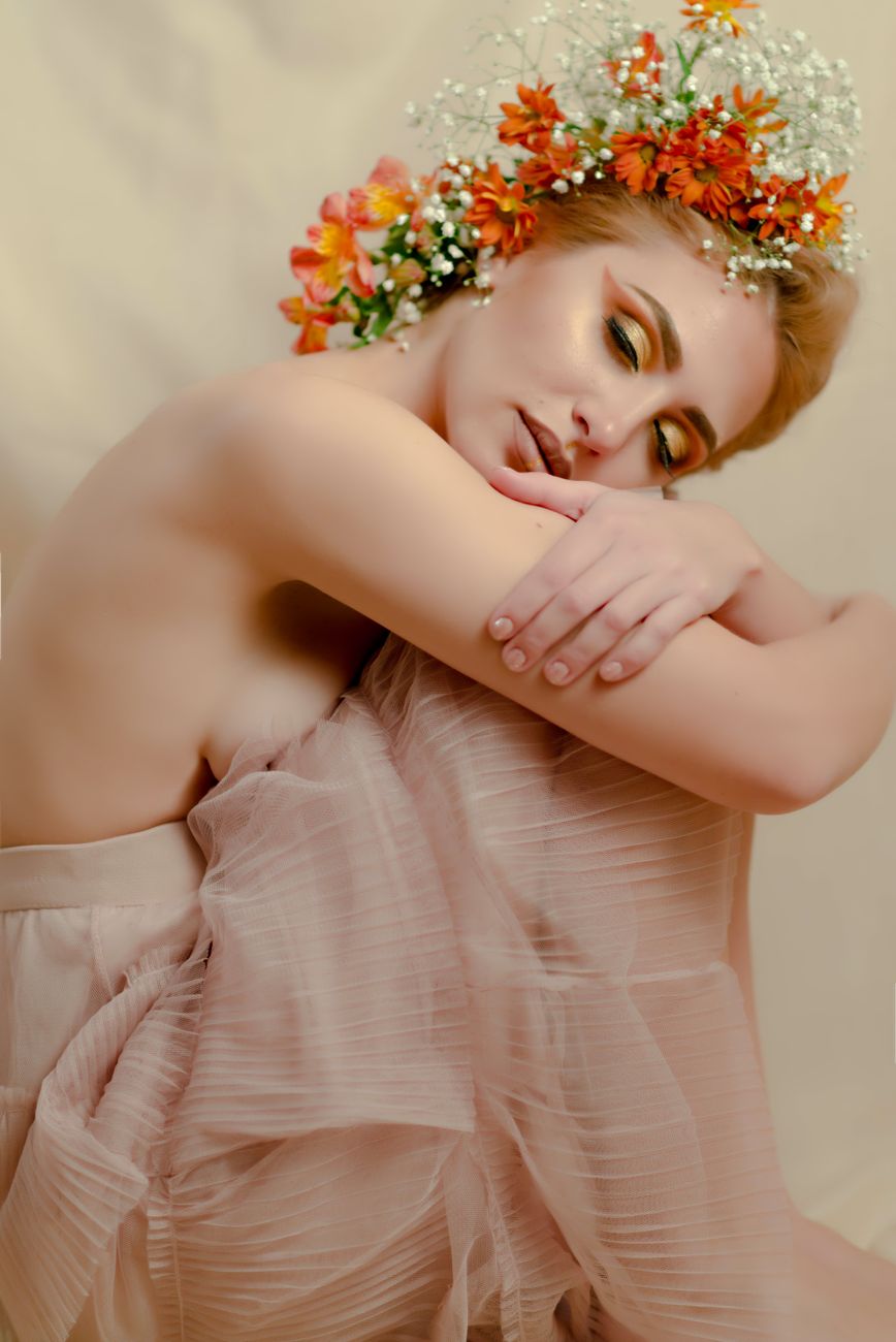 A serene portrait of a woman with vibrant floral headpiece, embodying grace and elegance.