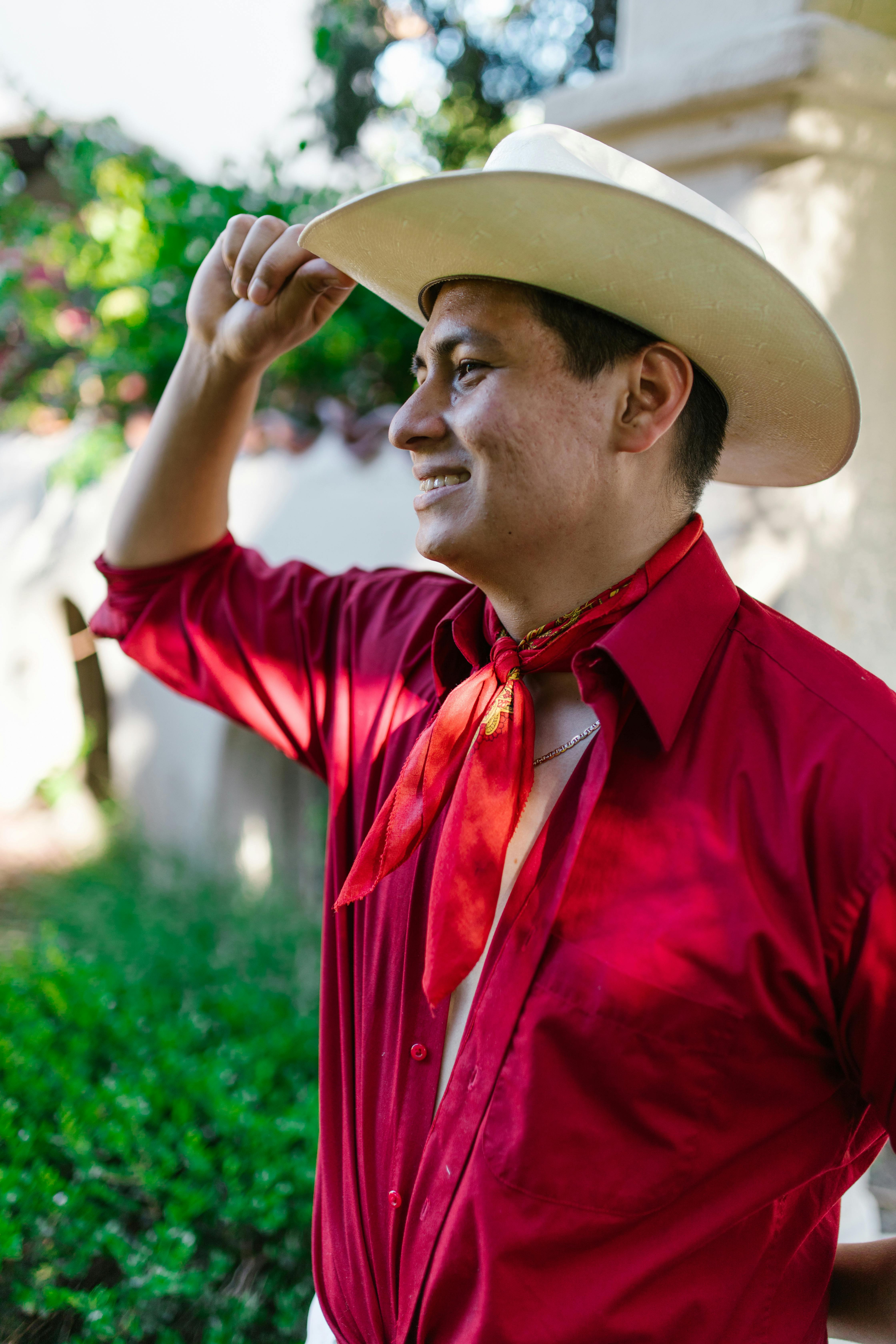 man in red button up shirt wearing brown cowboy hat