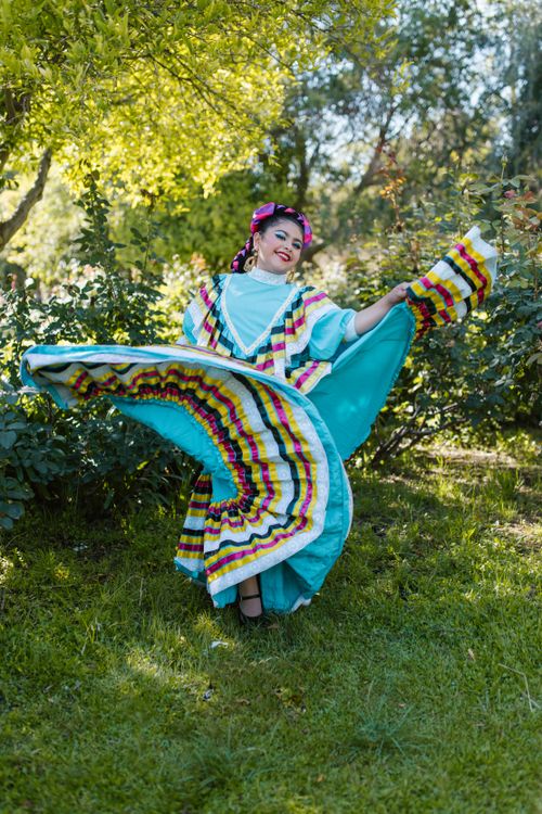 Free Colorful Mexican dancer in traditional dress gracefully twirling outdoors. Stock Photo