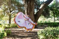 Woman in White and Red Dress Sitting on Brown Tree Trunk