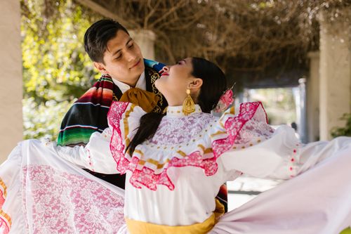 Free A couple in vibrant traditional Mexican costumes dancing outdoors, showcasing cultural heritage and joy. Stock Photo