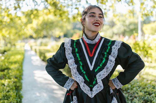 Free Pretty Young Dancer in Traditional Dark Green Pollera Dress on Walkway in the Park Stock Photo