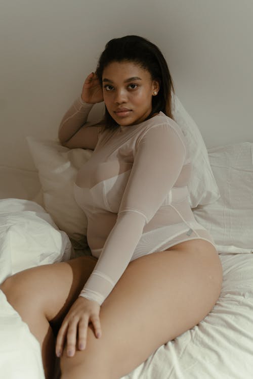 A Woman in White Long Sleeve Shirt Lying on the Bed