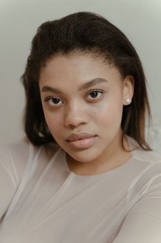 Elegant close-up portrait of a young woman with soft lighting indoors.