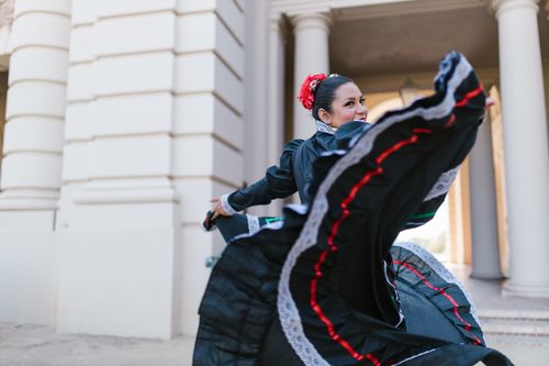Free A woman in traditional Mexican attire dances gracefully outdoors, showcasing her cultural heritage. Stock Photo