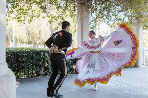 Free Man and a Woman in Traditional Clothes Dancing Together Stock Photo