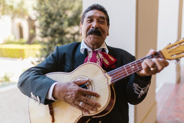 Man In Traditional Outfit Playing Guitar