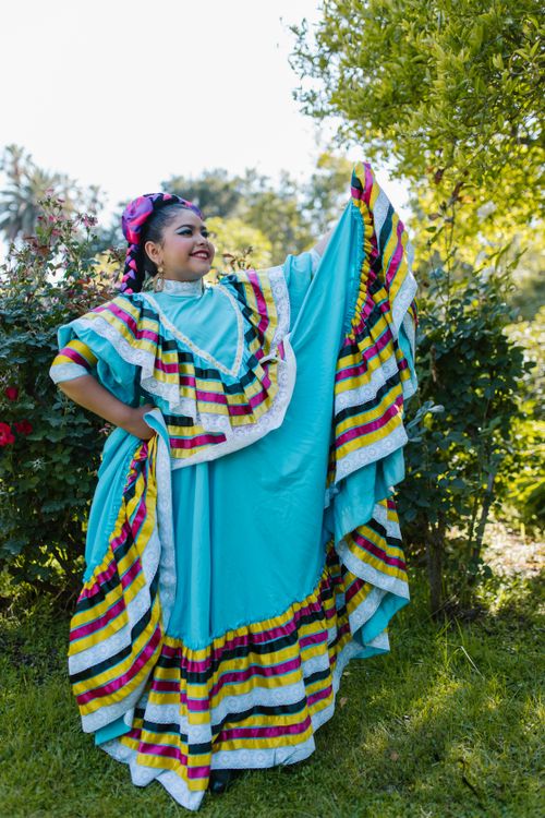 Free Vibrant portrait of young woman in traditional Mexican dress, celebrating outdoors. Stock Photo