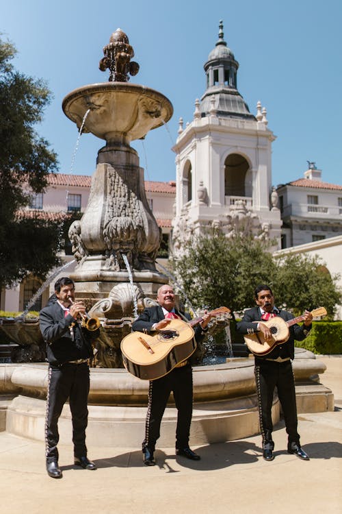 Free Men Playing Musical Instruments in Front of the Water Fountain Stock Photo