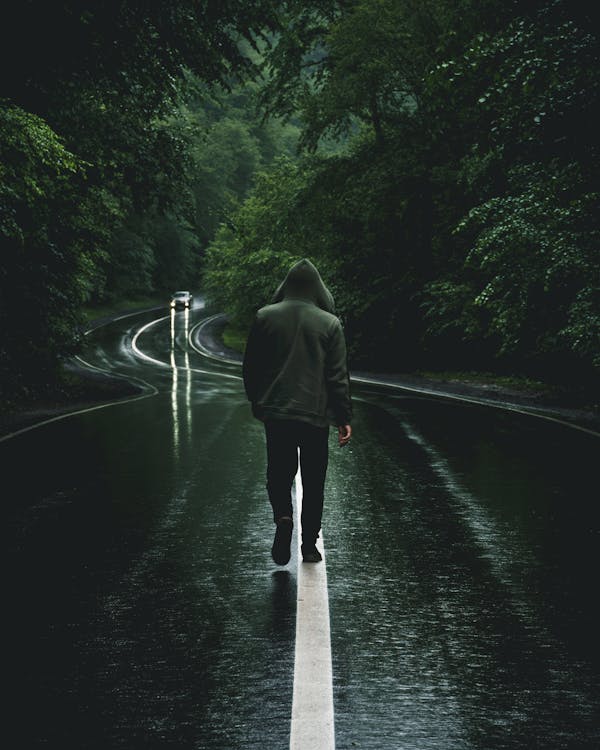A Man in Black Jacket Walking on the Road · Free Stock Photo