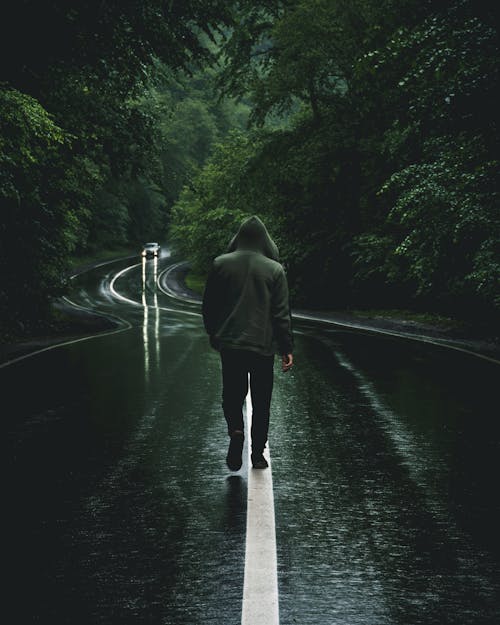 A Man Walking on the Asphalt Countryside Road · Free Stock Photo