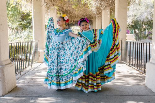 Free Two women in vibrant Mexican traditional dresses pose outdoors, celebrating culture with joyful expressions. Stock Photo
